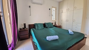 A bedroom with a bed, nightstands, a wardrobe, and a window. - Casa Elysia 3BR with beach and pool (Platanias)
