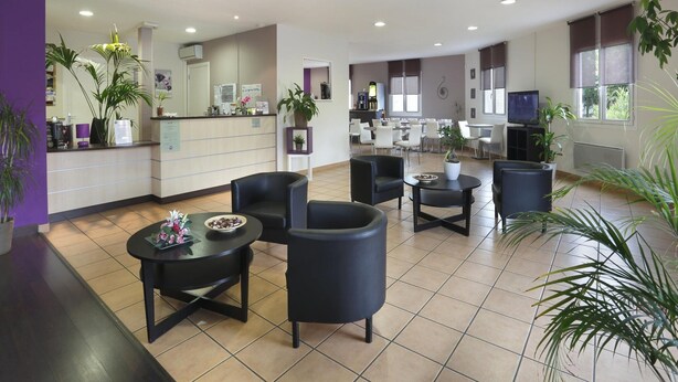 Eine Hotte lobby mit einer Rezeption, einer Sitzecke und einem Fernseher.