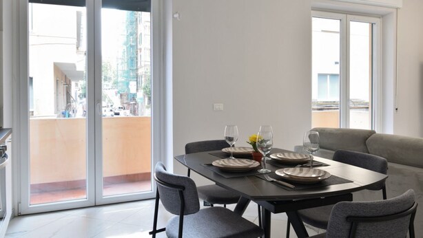 A dining area with a table set for four, chairs, and a view through glass doors to an outdoor balcony. - Bright and spacious apartment of approximately 80 square meters, perfect for four people, located on the first floor of a building with an elevator (NOT accessible to disabled guests).The property is located in the Sampierdarena neighborhood, one of the  (Genova)
