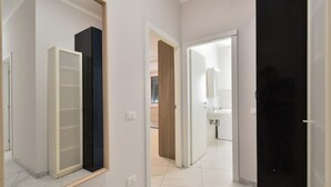 A hallway with a mirrored wardrobe, a door leading to a bathroom, and a tiled floor. - Bright and spacious apartment of approximately 80 square meters, perfect for four people, located on the first floor of a building with an elevator (NOT accessible to disabled guests).The property is located in the Sampierdarena neighborhood, one of the  (Genova)