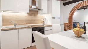Una cocina moderna con armarios blancos, encimera de madera y un arco de ladrillo.