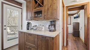 Una cocina con armarios de madera, una encimera con equipo para preparar café y vistas al exterior.