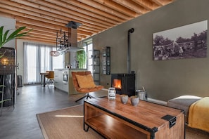A modern living room with a fireplace, a dining area, and a kitchen. - Lennepserf - De Achterhoek (Veessen)