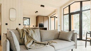 A modern living room with a sofa, a coffee table, and a large window.