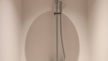 A shower with a handheld showerhead and a wall-mounted control.