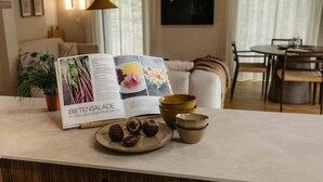 A kitchen counter with a cookbook, a potted plant, and a plate with food items.