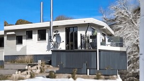 A single-story house with a garage, a covered porch, and a clear blue sky.