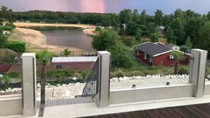 A residential area with a lake, houses, and a stormy sky.