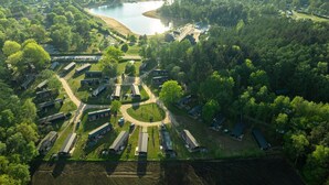 An aerial view of a campground with RVs, cabins, and a lake. - Wilsumer Berge Resort - Glamfield Lodge 4p (Wilsum)