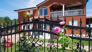 A two-story house with a balcony, a wrought iron fence, and blooming flowers. - Countryside Oasis in Valica (Umag)