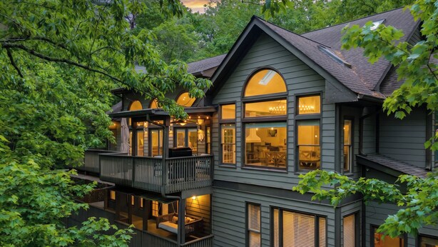 A two-story house with a balcony, large windows, and a porch area. - Modern Marble - Big Canoe, GA (Jasper)
