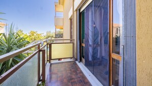 A balcony with a metal railing, a sliding glass door, and a view of the surrounding greenery. - Il Giardino by Wonderful Italy (Sanremo)