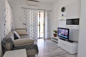 A modern living room with a sofa, TV, and a potted plant. - Peaceful Countryside Stay With Terrace (Umag)