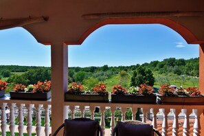A balcony with a view of a green landscape, white balustrade, and flower planters. - Peaceful Countryside Stay With Terrace (Umag)