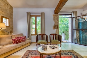 Een gezellige woonkamer met een bank, twee fauteuils, een salontafel en een kamerkleed.