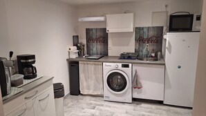 A compact kitchen with a washing machine, a microwave, and a coffee maker. - Provencal village between Aix en Provence and Cassis (Fuveau)