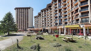 A multi-story hotel with balconies, outdoor seating, and a picnic area. - Superb Apartment with Mountain View at the Foot of the Slopes (Villard-de-Lans)