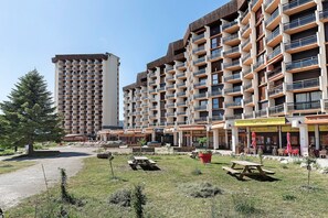 A multi-story hotel with balconies, outdoor seating, and a picnic area. - Superb Apartment with Mountain View at the Foot of the Slopes (Villard-de-Lans)