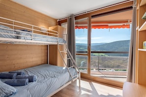 A bunk bed room with a view of a mountainous landscape through a large window. - Superb Apartment with Mountain View at the Foot of the Slopes (Villard-de-Lans)