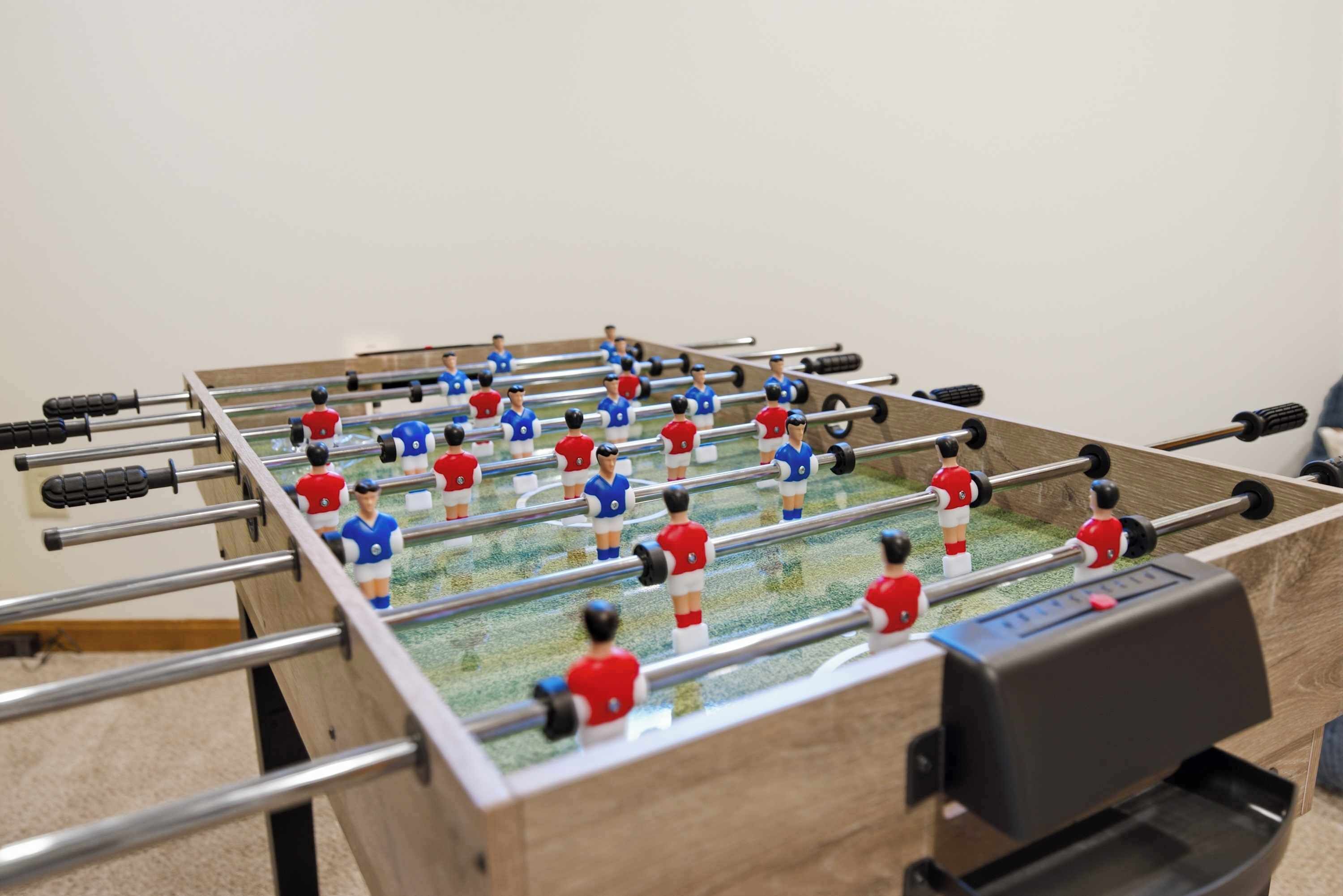 Una mesa de fútbolín con varios jugadores.