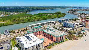 A coastal hotel with multiple buildings, a swimming pool, and a view of the river and cityscape. - Recently renovated BEACH condo, tons of amenities (Indian Shores)