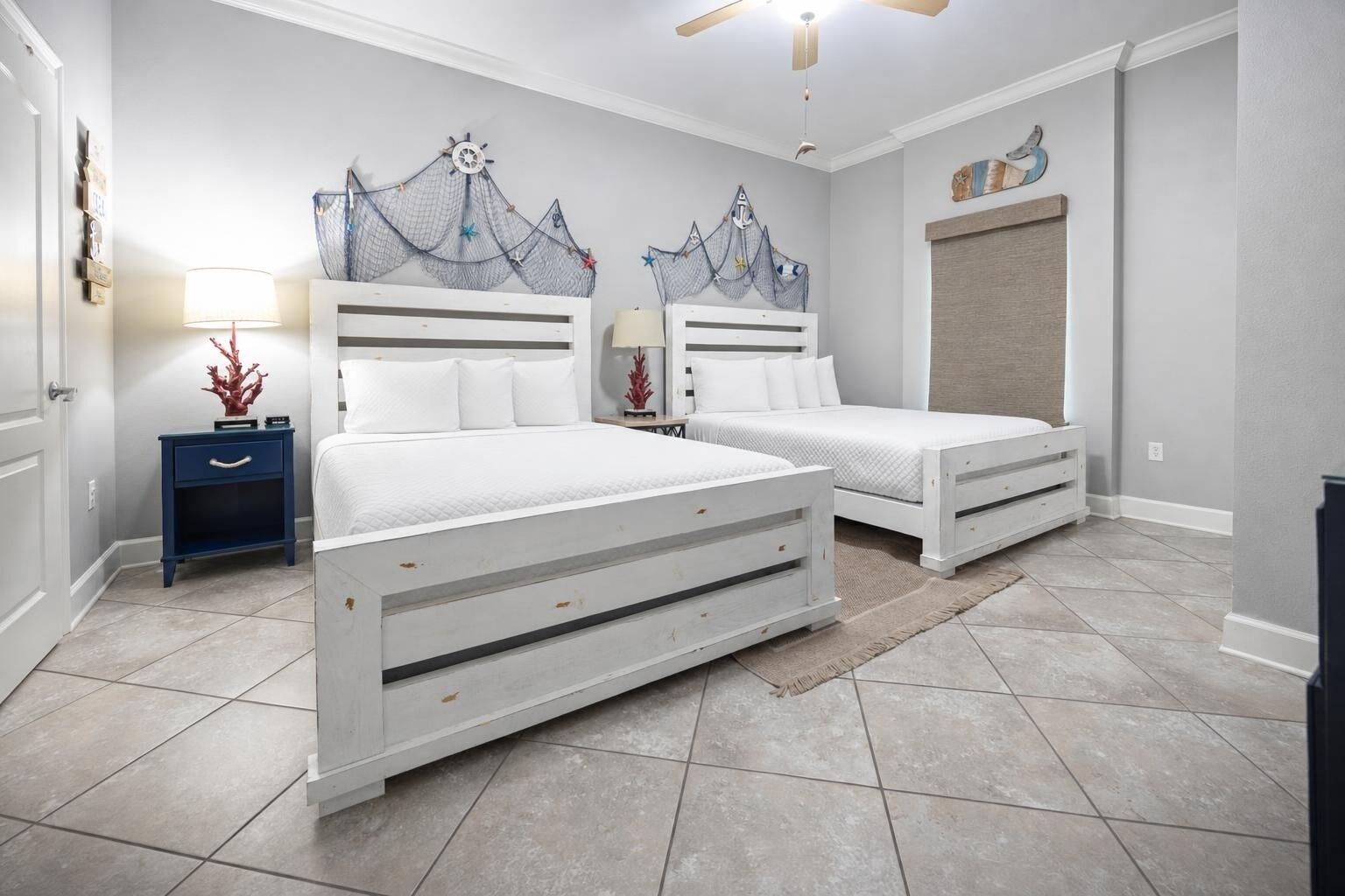 Quarto com duas camas, mesa de cabeceira, abajur e decoração na parede.