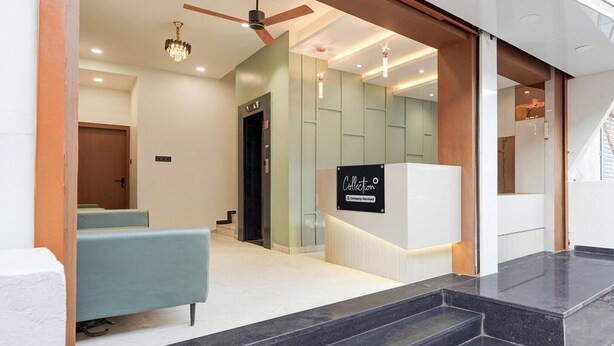 A modern reception area with a reception desk, a chandelier, and a ceiling fan.