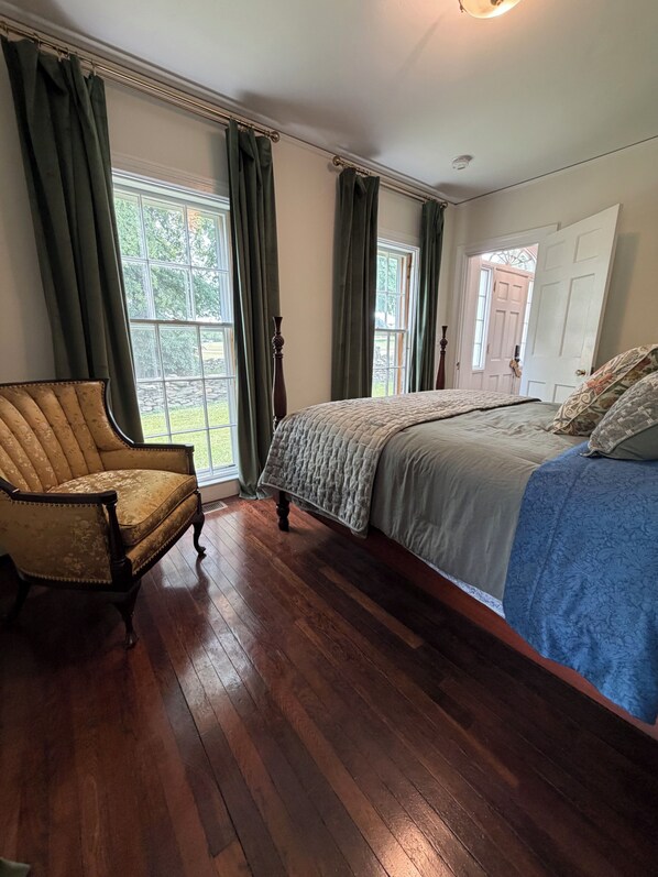 A bedroom with a bed, a chair, and a window.