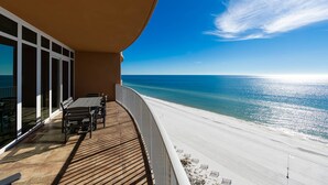 Ein Balkon mit Blick auf Strand und Meer.