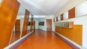 A corridor with wooden paneling, a radiator, and a tiled floor. - Il Giardino by Wonderful Italy (Sanremo)
