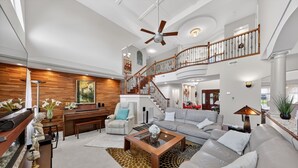A spacious living area with a high ceiling, a staircase, and a modern design. - Milford Quiet Coastal Retreat 3br Sleeps 8 3 Bedroom Home (Milford)