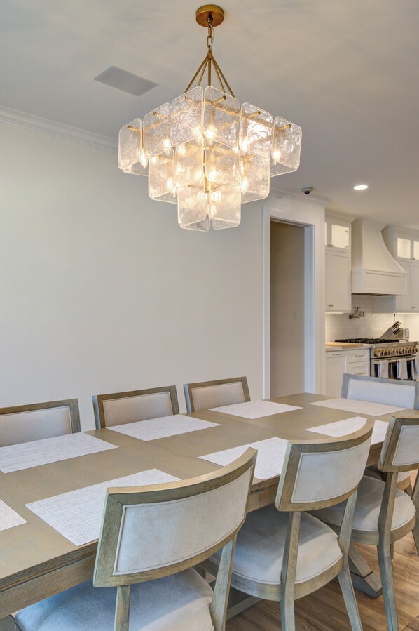 Un coin repas agrémenté d’un lustre, d’une table en bois et de chaises assorties.