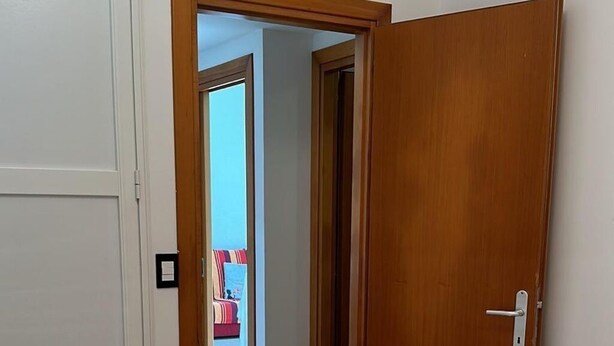 A bedroom with a bed, a door, and a view of a balcony. - Bright & Peaceful 2BR Apartment in Terracina (Terracina)
