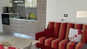 A modern kitchen with a dining area, a sofa, and a TV. - Bright & Peaceful 2BR Apartment in Terracina (Terracina)