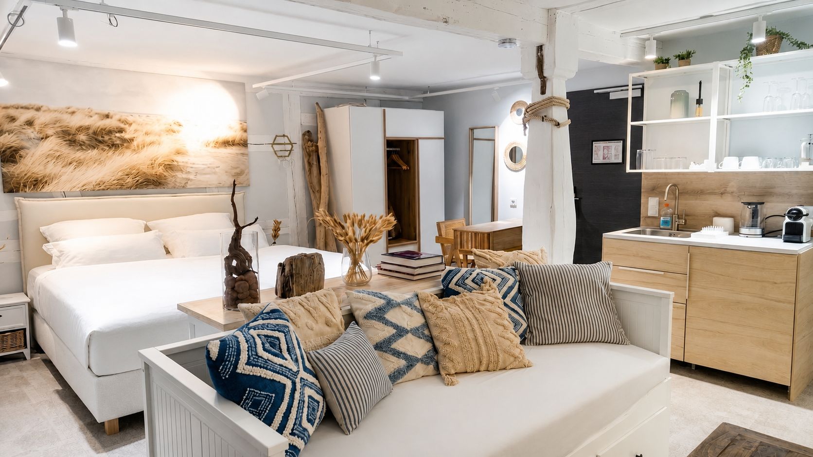 A modern interior with a bed, sofa, and kitchen area.