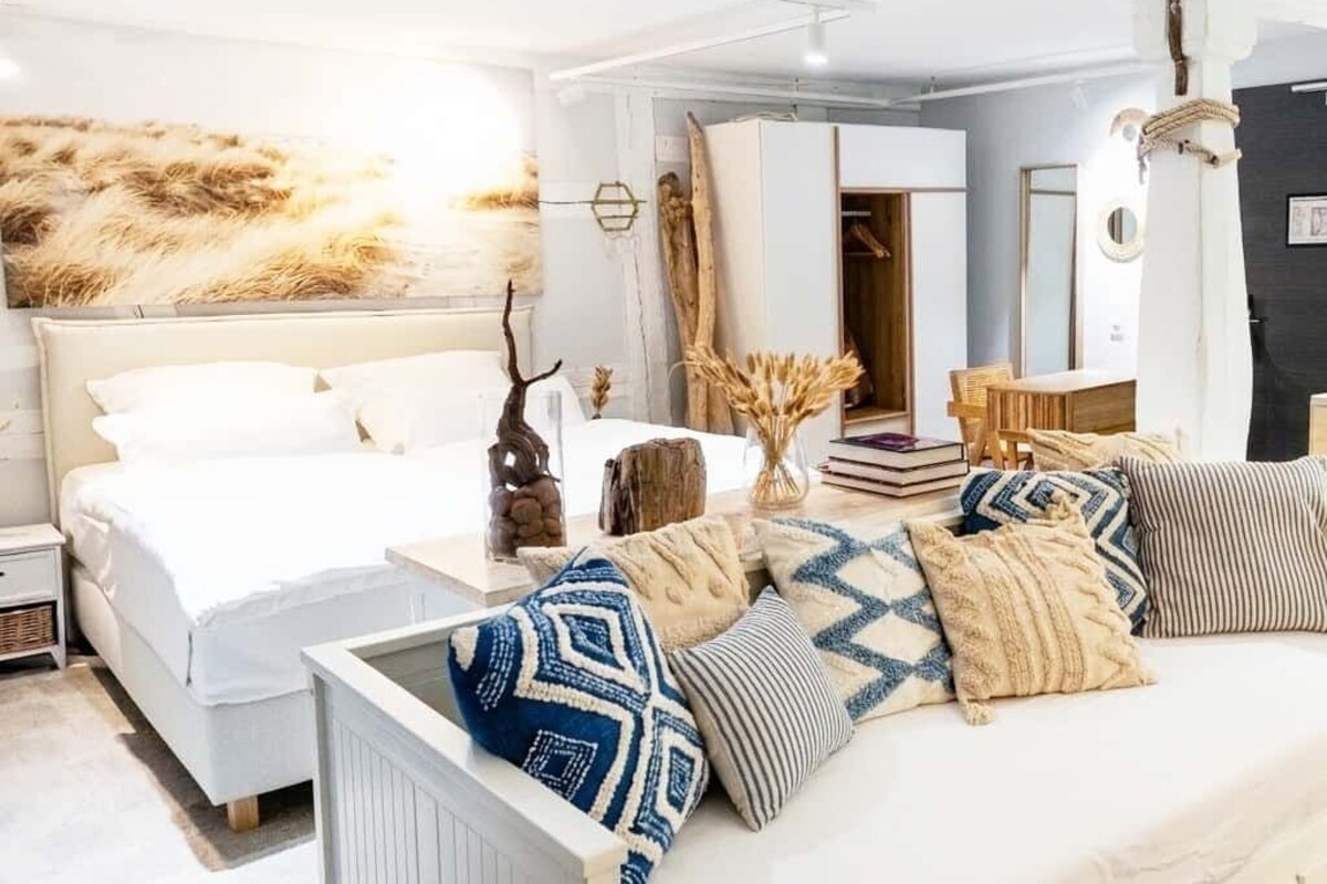 A modern bedroom with a large bed, bedside tables, and a variety of pillows.