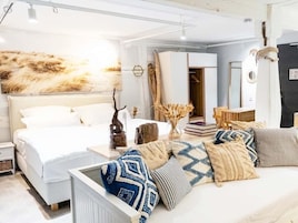 Un dormitorio moderno con una cama grande, mesitas de noche y una variedad de almohadas.