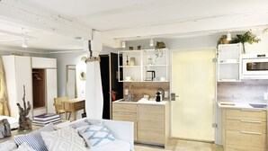 A modern kitchen with white cabinets, a microwave, and a sink. - NOX Hotel (Walzbachtal)