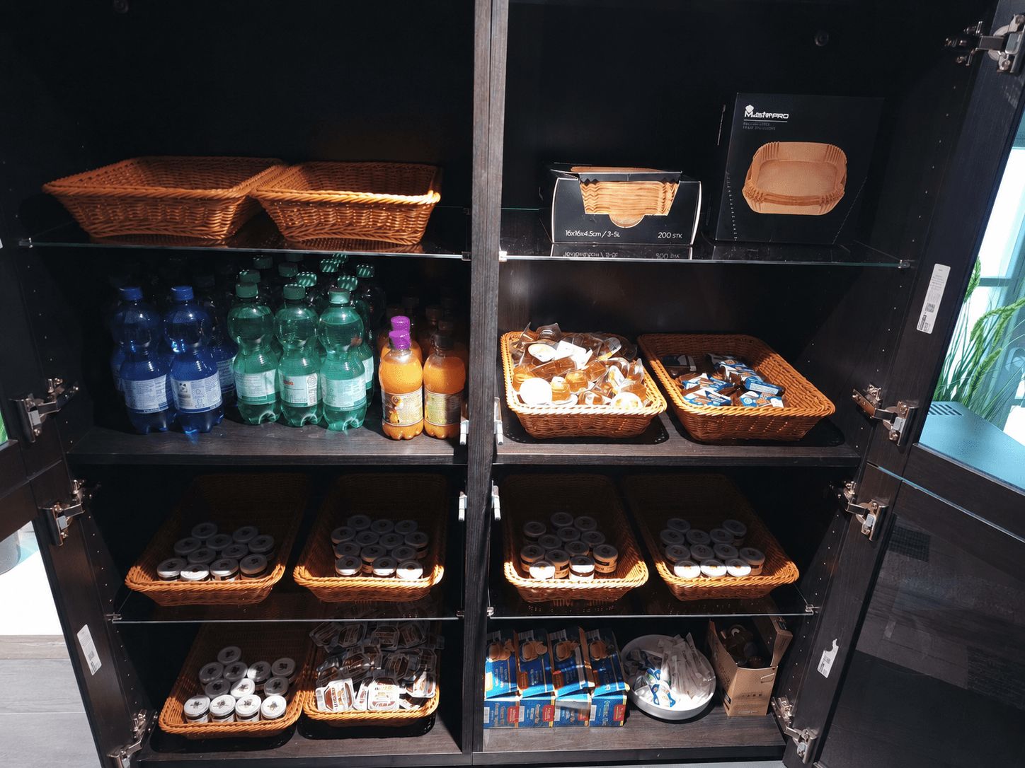 A storage unit with shelves containing various items including bottled water, snacks, and toiletries.