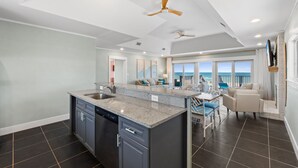A modern kitchen with granite countertops, a dishwasher, and a dining area with a view of the ocean. - Beachfront Breeze: Beachfront, Close to town center, Pet friendly, direct beach (St. George Island)