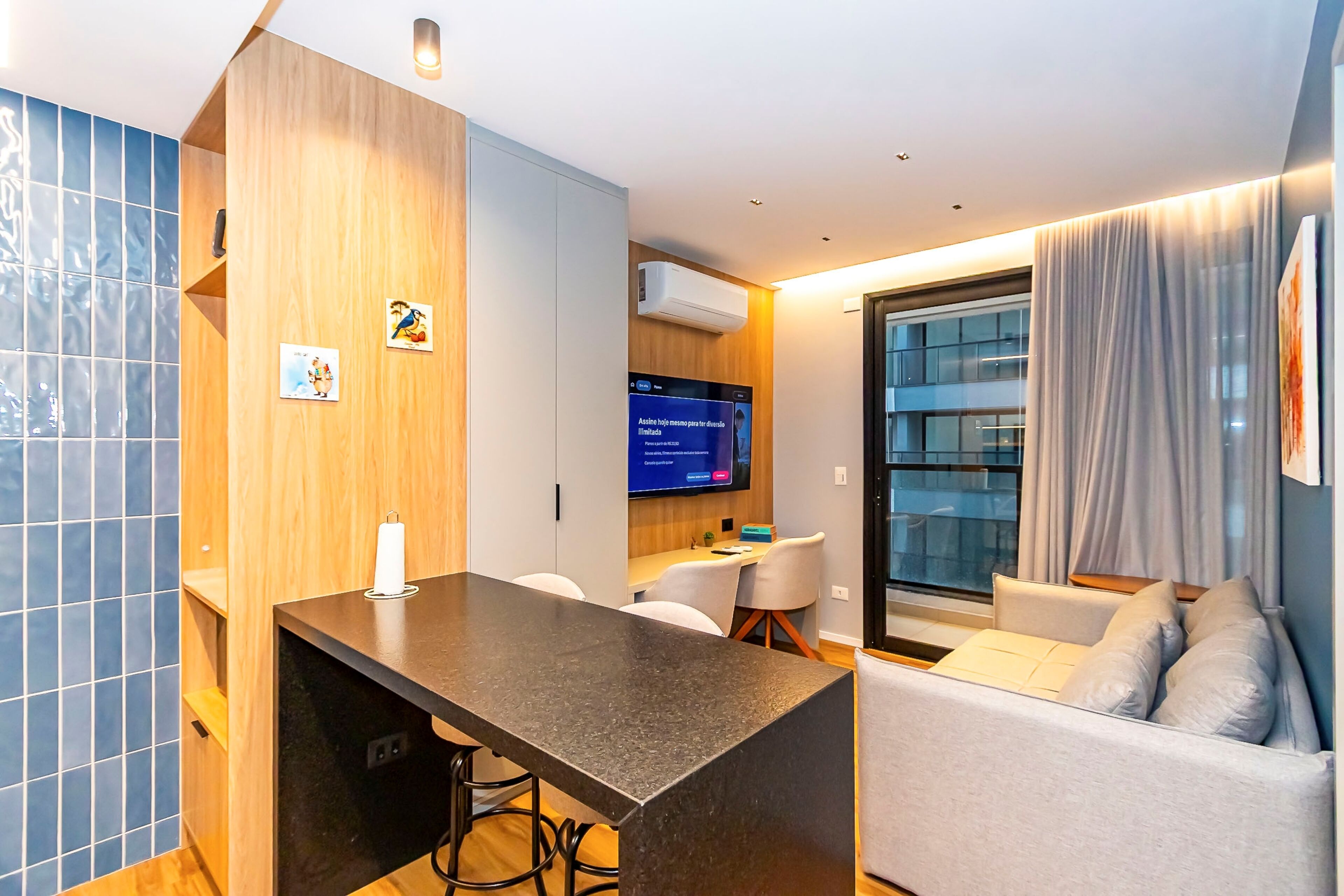 Una habitación de hotel moderna con cocina, una mesa de comedor y un sofá.