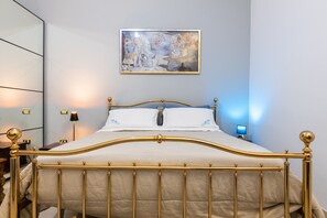 A bed with a gold frame, white bedding, and a painting above it. - By Domy 2 Grottaglie – Authentic Stay in the Heart of Puglia (Grottaglie)