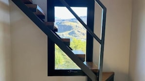 Un escalier moderne avec une fenêtre donnant sur un paysage montagneux.