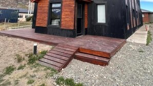 Un immeuble moderne à plusieurs étages, doté d’un toit plat, de grandes fenêtres et d’une petite structure en bois à l’avant.