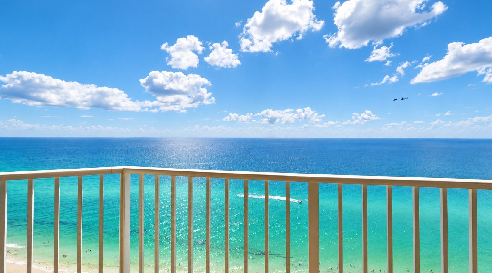 Een balkon met uitzicht op de oceaan en een heldere lucht.