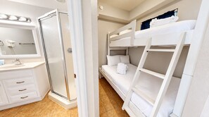 A room with a shower, a bed, and a bunk bed. - New to the Rental Program | Gulf-Front Views | Tidewater 2316 | Beachfront (Panama City Beach)