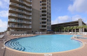 A swimming pool with a 3 FT depth marker, surrounded by lounge chairs and a multi-story building with balconies. - New to the Rental Program | Gulf-Front Views | Tidewater 2316 | Beachfront (Panama City Beach)