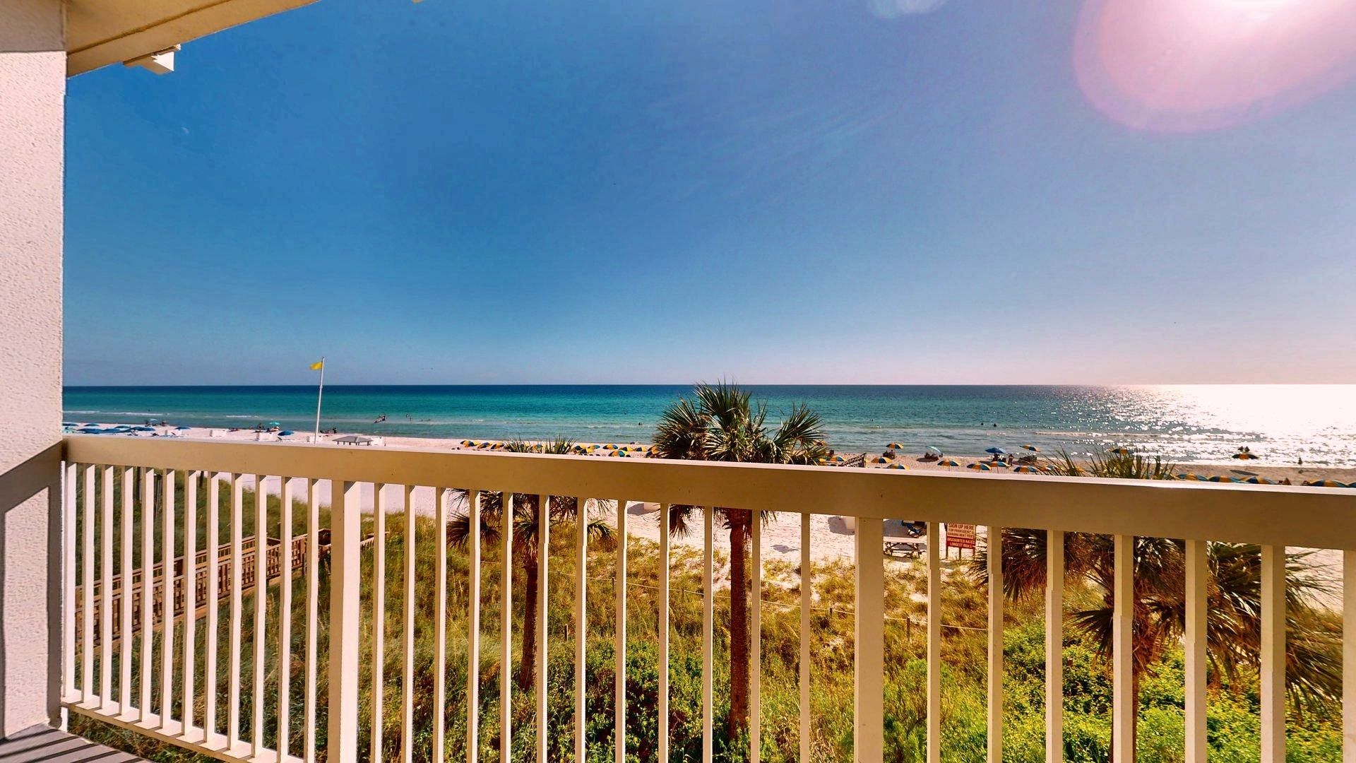 Ein Balkon mit Blick auf Strand und Meer.