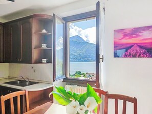 Eine Küche mit Fenster, einem Esstisch mit Stühlen und einem Heizkörper.