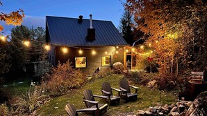 A rustic cabin with a metal roof, wooden deck, and string lights. - 19th-century chalet with all modern comforts, 2 bedrooms, 1 bathroom (Saint-Barthélemy)